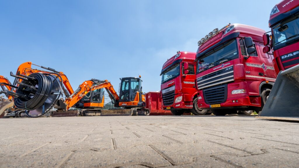 Wagenpark en materieel van Bronboringenter: transporttrucks, graafmachines en haspel met leidingen voor bronboring