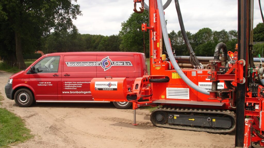 Bronboringenter boorinstallatie op rupsbanden met servicebus op locatie voor professionele bronboring en waterbron boren